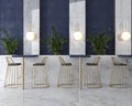 Café lignende setting med høje stole og borde og Precious White marmor fliser på væg og gulv