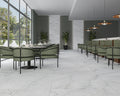 Fællesområde med hvid borde, grønne stole og Precious White marmor fliser på væg og gulv