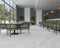 Fællesområde med hvid borde, grønne stole og Precious White marmor fliser på væg og gulv