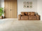 Stueområde med sofa og petrae beige gulvfliser i betonlook