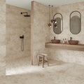 Moderne badeværelse med to vaske, to spejle, en bruser og Petrae Natural fliser i betonlook på vægge og gulv
