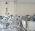 Badeværelse med bruser og badekar på Ravello Azzurro marmor gulvfliser