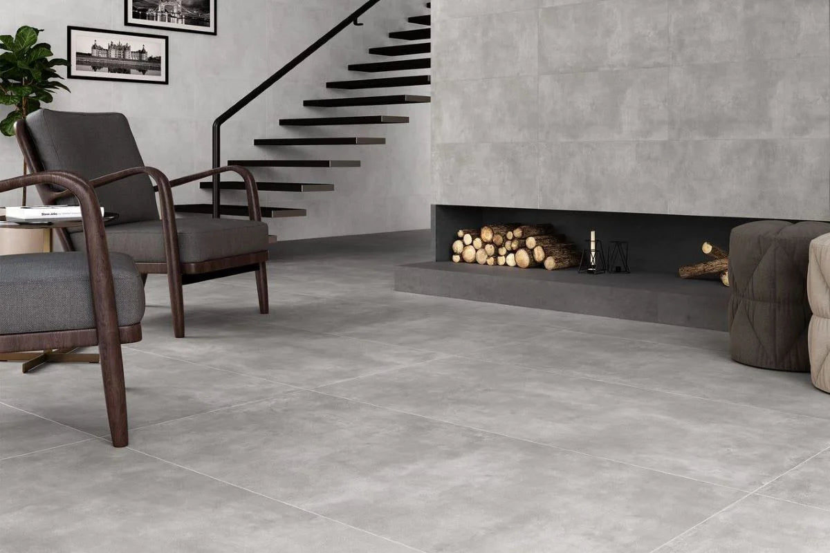 Moderne stueområde med stole, pejs og trappe med Oyster Grey fliser i betonlook på vægge og gulv